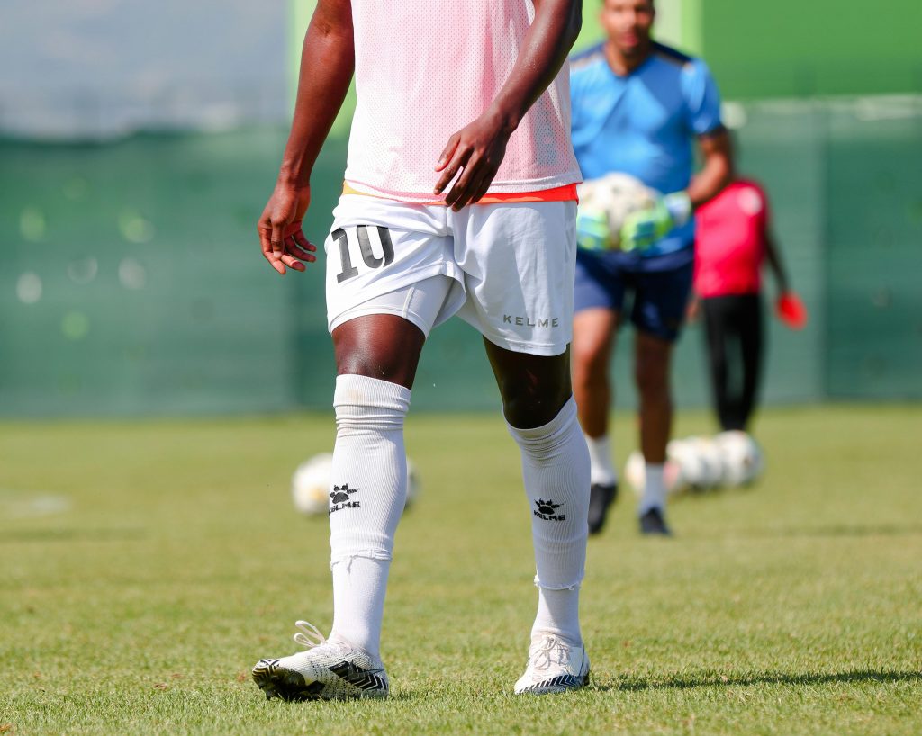 pexels photo 9701146 9701146 A soccer player in sportswear practices on a green field during a sunny day.